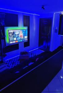 a living room with a tv in a blue room at Quarto Pernoite em apartamento Guarulhos Aeroporto Fast Sleep Individual in Guarulhos