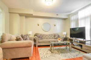 a living room with a couch and a tv at Baltimore Vacation Rental - Near JHU and Art Museum! in Baltimore