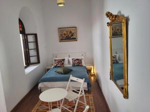 a small bedroom with a bed and a mirror at Riad Tazi Casablanca in Casablanca