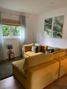 a living room with a couch and a table at Garden Retreat Wales in Llandowror