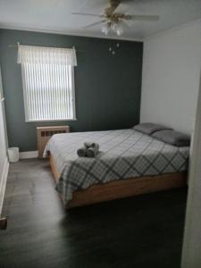 a bedroom with a bed with a teddy bear on it at La Maison Vaillancourt in Saint-Laurent-de-l'ile d'Orleans