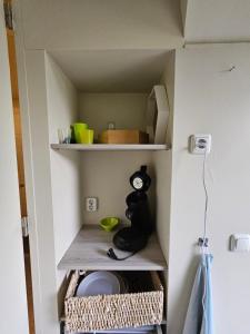a small kitchen with a cupboard with some food at Bij Het BuitenGoed in Rijsbergen