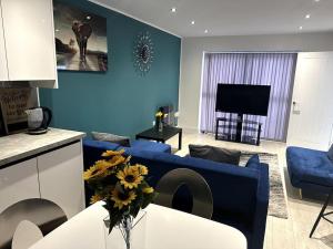 a blue living room with a blue couch and a table at KYOTO HOUSE CENTRAL DERBY I 2 BEDROOMS, SPACIOUS, WARM & NEW with NETFLIX in Derby