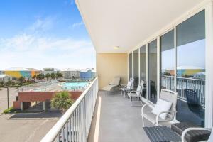 ガルフ・ショアーズにあるSanibel 306- Easy beach access & Gulf viewsのプールの景色を望むバルコニー(椅子付)