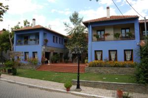 a blue house with flowers on the balconies at Safetis Stories in Díon