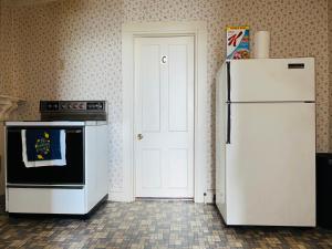 eine Küche mit einem weißen Kühlschrank und einer weißen Tür in der Unterkunft Pacifico's Place "A" in Hartford