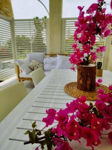 a white table with pink flowers on top of it at Sicilia Noto San Lorenzo Villa Amaranto in San Lorenzo
