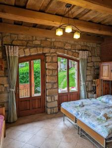 a bedroom with a bed and a stone wall at Roubenka in Červený Kostelec