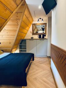 a bedroom with a blue bed and a kitchen at Willa Wysoka in Zakopane