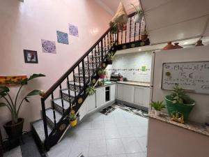 una escalera en una cocina con plantas en la pared en Riad dar sahrawi en Marrakech