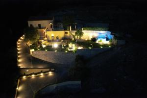 - une vue aérienne de nuit sur une maison éclairée dans l'établissement La Cornice dei Monti, à Tramonti