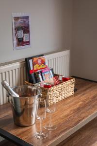 a table with two wine glasses and a basket of food at OAKWOOD GLAMPING Mourne Mountains in Moyad