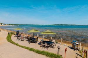 a group of tables and chairs with umbrellas on a beach at Tamarack Lodge in Traverse City