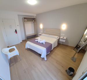 a bedroom with a bed with two towels on it at La familia in Santa Ana (Urb. Riachuelos 2)