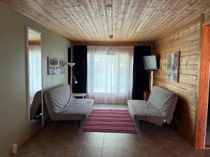 ein Wohnzimmer mit zwei Stühlen und einem Fernseher in der Unterkunft Taljatie Apartments in Rovaniemi