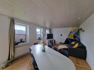 a living room with a white table and a couch at Willkommen in Frifelt Nähe Rømø mit wunderschönen Garten in Skærbæk