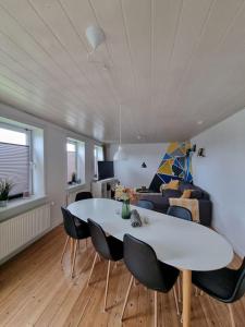 sala de estar con mesa blanca y sillas en Willkommen in Frifelt Nähe Rømø mit wunderschönen Garten en Skærbæk
