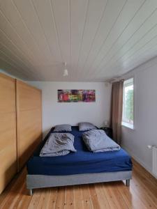 ein Schlafzimmer mit einem blauen Bett in einem Zimmer in der Unterkunft Willkommen in Frifelt Nähe Rømø mit wunderschönen Garten in Skærbæk
