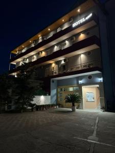 un edificio con un cartel en él por la noche en Hotel Kaloshi, en Tirana