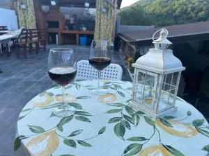 two glasses of wine on a table with a lantern at COMPLEX TURISTIC Gradina de corzi si Aventura Eselnita in Eşelniţa +18 photos