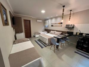 Habitación hospitalaria con cama, mesa y sillas en Éolos Loft's - Cabo Frio en Cabo Frío