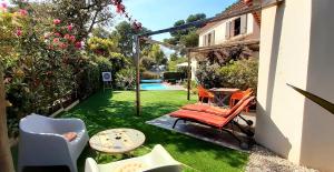 a patio with chairs and a table and a pool at Le Clos des Barelles in Six-Fours-les-Plages