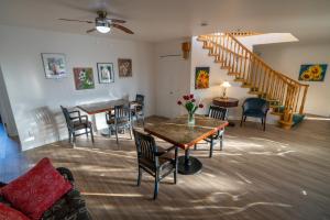 a living room with a table and chairs and a staircase at Sonora Desert Inn in Osoyoos