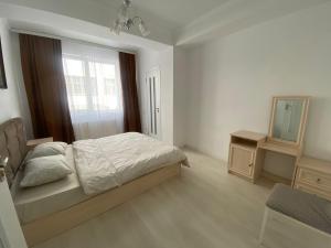 Schlafzimmer mit einem Bett, einem Spiegel und einem Fenster in der Unterkunft Аэропорт Апартаменты 24&24 in Chişinău