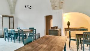 comedor con mesa de madera y sillas en Masseria Celeste, en Fasano