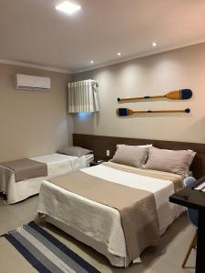 1 dormitorio con 2 camas con bates de béisbol en la pared en Éolos Loft's - Cabo Frio en Cabo Frío
