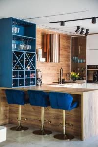 a kitchen with a wooden counter and blue bar stools at Domek Gucci in Jejkowice