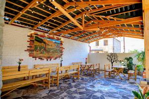 a patio with wooden benches and tables and a painting at Areni Wine Cellar in Areni