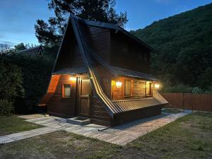 a small wooden house with lights on it at Chata nad Popradem, Rytro in Rytro