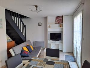 un salon avec un canapé et une télévision dans l'établissement Maison au calme, à Camiers