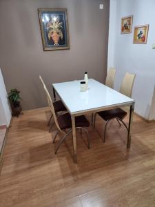 - une table et des chaises blanches dans la chambre dans l'établissement Cozy Apartment, à Strumica