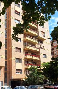 un edificio alto con macchine parcheggiate di fronte di La casa di Viola - Trastevere a Roma