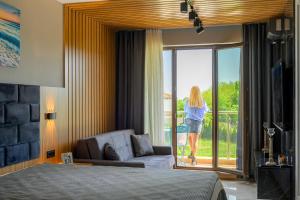 a woman walking out the door of a bedroom at Azur Properties 74 in Shkorpilovtsi +25 photos