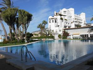 a large swimming pool in front of a white building at Studio Vue Mer in Torremolinos