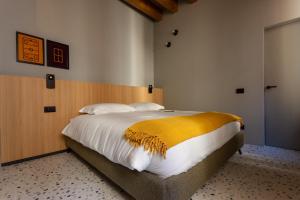 a bedroom with a large bed with a yellow blanket at Residenza San Longino in Mantova