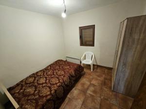 ein Schlafzimmer mit einem Bett und einem Stuhl darin in der Unterkunft Alpe House Korita in Podgorica + 3 Fotos
