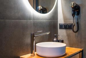 Un lavabo de baño con grifo y espejo. en Soul Bobolin Homes, en Bobolin