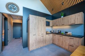 una cocina con armarios de madera y un reloj en la pared en Soul Bobolin Homes, en Bobolin