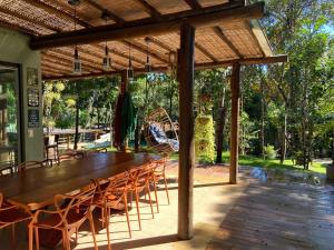 uma mesa de madeira e cadeiras sob um pavilhão em CASA PRAIA DO FORTE em Mata de Sao Joao