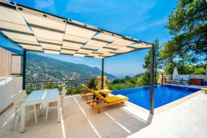 a patio with a table and chairs and a swimming pool at Villa Huzurlu in Kaş
