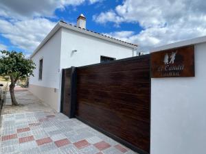 a white house with a wooden garage door at Casa rural El Candil in Olivenza