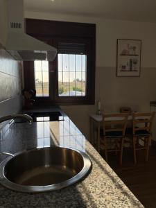 a kitchen with a sink and a kitchen with a table at Casa rural El Candil in Olivenza