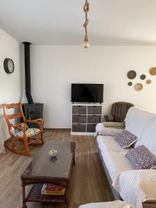 a living room with a couch and a flat screen tv at Casa rural El Candil in Olivenza +42 photos