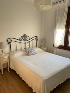 a bedroom with a large bed with white sheets and a window at Casa rural El Candil in Olivenza +46 photos