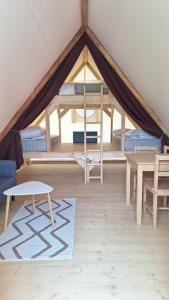 Una habitación con una tienda de campaña con camas y una mesa en les cabanes du tertre, en Cour-Cheverny