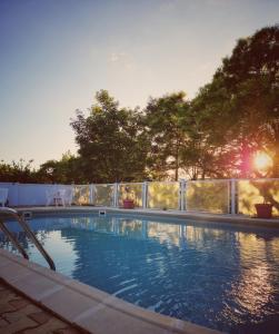 una gran piscina con una valla y árboles en Tempo Hôtel, en Millau